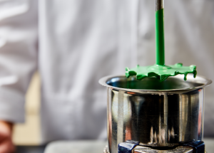 A micro paint blender dripping with green paint.