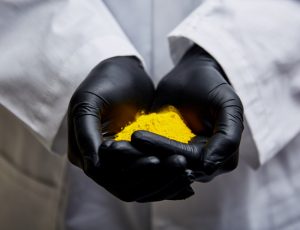 Chemist holding a yellow pain sample